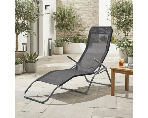 Scène de jardin avec une chaise longue en métal et revêtement textile