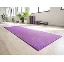 Tapis de yoga violet sur plancher de bois clair dans une pièce lumineuse avec accessoires de yoga
