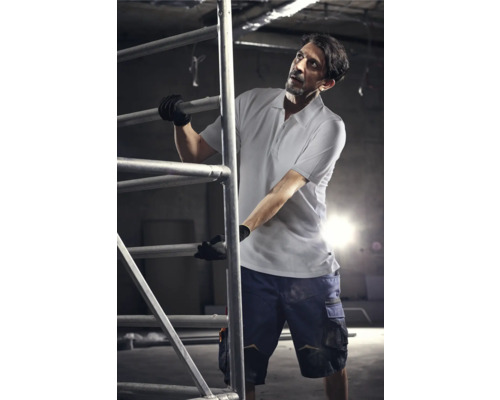 Homme sur un échafaudage portant des vêtements de travail et des gants