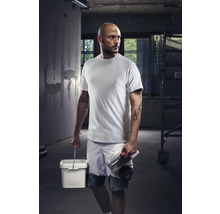 Artisan avec T-shirt, short, seau et truelle sur un chantier