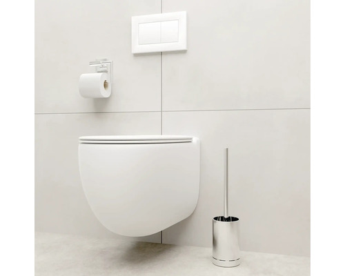 WC suspendu avec plaque de commande, porte-papier toilette et brosse de toilette dans une salle de bain lumineuse.