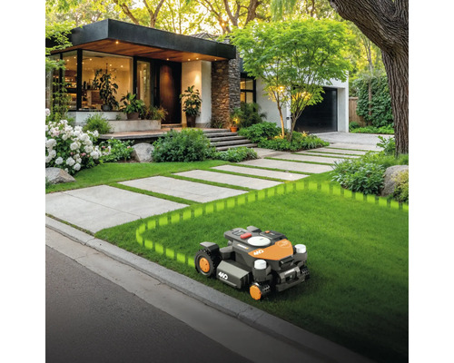 Rasenmähroboter im Einsatz vor modernem Wohnhaus mit gepflegtem Garten