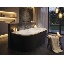 Salle de bains élégante avec baignoire îlot, bougies et éclairage indirect pour une atmosphère relaxante