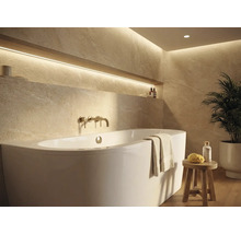 Salle de bains lumineuse avec baignoire, robinetterie et étagère avec décoration