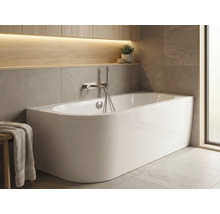 Baignoire îlot dans salle de bains lumineuse avec espace de rangement