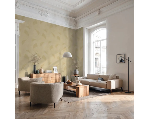Salon lumineux avec canapé, fauteuils, table en bois et éléments décoratifs.