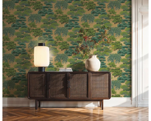 Papier peint décoratif vert avec motif d'arbres derrière une armoire en bois dans la pièce.