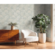 Salon avec papier peint arbre, commode, fauteuil et plantes en pot pour une ambiance cosy
