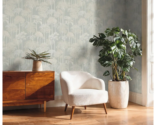 Salon avec papier peint arbre, commode, fauteuil et plantes en pot pour une ambiance cosy
