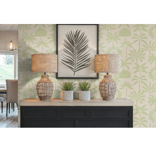 Scène décorative avec deux lampes, des plantes et une image encadrée sur une commode devant un papier peint à motifs de palmiers