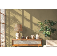 Scène décorative avec lampe de table, vases, table et plante d'intérieur devant un mur