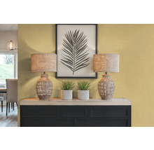 Intérieur décoratif avec deux lampes de table, des plantes et une impression de feuille encadrée sur un buffet