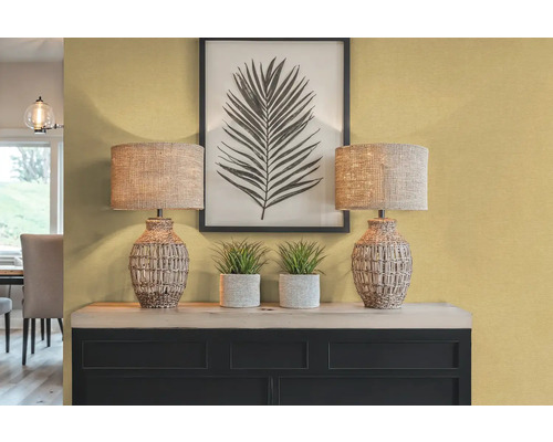 Intérieur décoratif avec deux lampes de table, des plantes et une impression de feuille encadrée sur un buffet