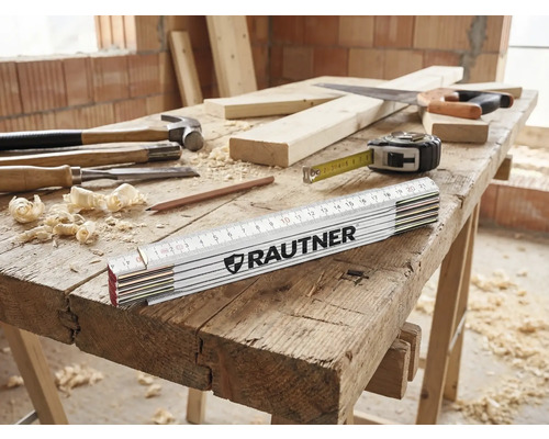 Werkbank mit Hammer, Stechbeitel, Zollstock der Marke Rautner, Bleistift, Holzwolle, Säge und Maßband