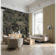 Salon moderne avec papier peint à motif de palmiers, meubles rembourrés clairs, table en bois et parquet en chevrons.