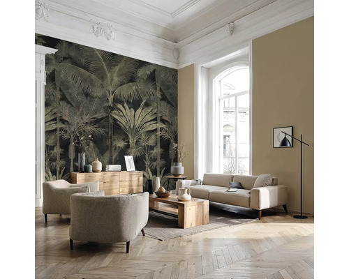 Salon moderne avec papier peint à motif de palmiers, meubles rembourrés clairs, table en bois et parquet en chevrons.