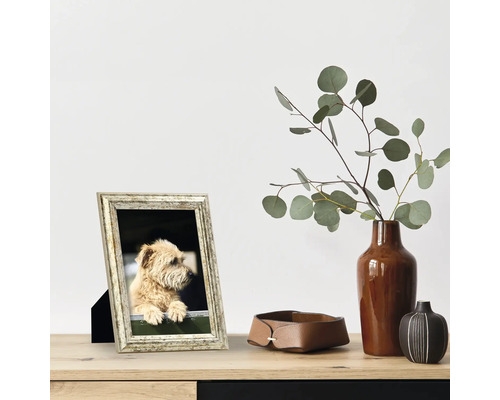 Scène décorative avec cadre photo, vase avec eucalyptus et plateau de rangement en cuir sur une table