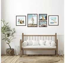 Décoration murale avec une sélection d'images encadrées au-dessus d'un canapé en bois