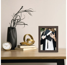 Cadre photo décoratif avec photo d'une diplômée sur une table avec des décorations.