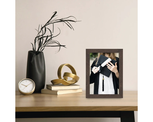 Cadre photo décoratif avec photo d'une diplômée sur une table avec des décorations.