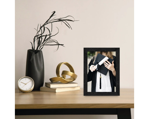 Table décorative avec cadre photo, vase et horloge