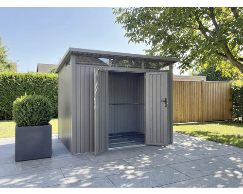 Abri de jardin métallique avec portes ouvertes dans le jardin