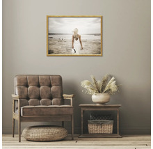 Salon décoratif avec fauteuil, table d'appoint et image de plage encadrée au mur