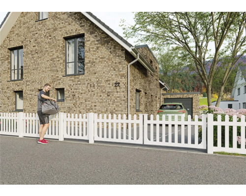 Clôture de jardin blanche devant une maison d'habitation.