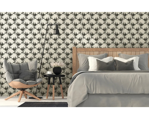 Schlafzimmer mit floral gemusterter Tapete, Bett, Sessel und Stehlampe