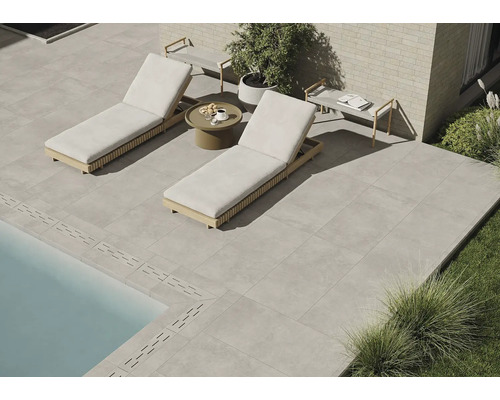 Terrasse mit Steinzeugfliesen, zwei Liegen aus Holz und einem Beistelltisch
