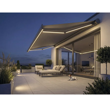 Terrasse mit Markise, Gartenmöbeln und Beleuchtung am Abend