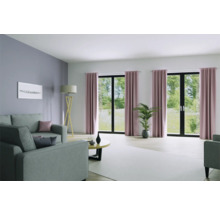 Wohnzimmer mit Sofa, Stehlampe, Tisch und Vorhängen vor Fenstern