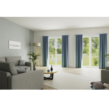 Heller Wohnraum mit Sofa, Stehlampe, Tisch und Vorhängen