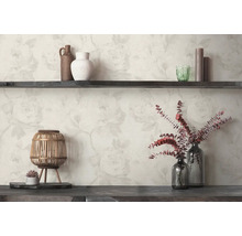 Papier peint avec un motif de roses claires derrière une étagère en bois sombre avec des vases, une lanterne et des fleurs séchées.