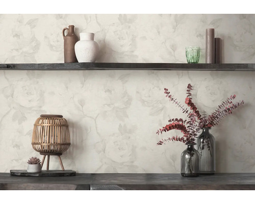 Papier peint avec un motif de roses claires derrière une étagère en bois sombre avec des vases, une lanterne et des fleurs séchées.