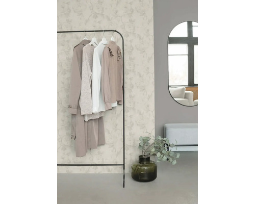 Pièce organisée et lumineuse avec papier peint intissé à motif floral, portant à vêtements en métal, miroir mural ovale et banc.