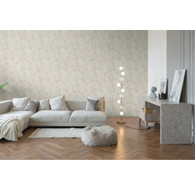 Salon lumineux avec papier peint intissé à motif floral, parquet en bois à bâtons rompus, canapé moderne et lampadaire.