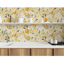 Fond de hotte pour cuisine avec un motif illustré de citrons et de feuilles dans une cuisine lumineuse avec plan de travail blanc et meubles en bois.