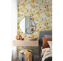 Papier peint intissé avec motif de citrons dans une chambre avec miroir organique, console suspendue et lit capitonné gris.
