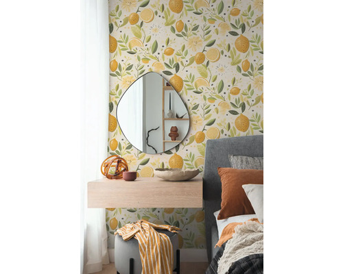 Papier peint intissé avec motif de citrons dans une chambre avec miroir organique, console suspendue et lit capitonné gris.