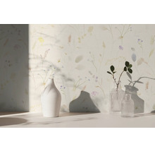 Vliestapete mit feinem floralem Muster aus Gräsern und Blumen im Aquarell-Stil, kombiniert mit Vasen in einem hellen Raum.