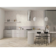 Helle, moderne Küche mit floraler Tapete, gestreiftem Spritzschutz, Kochinsel, schwarzen Barhockern und hellem Boden in Fischgrätoptik.