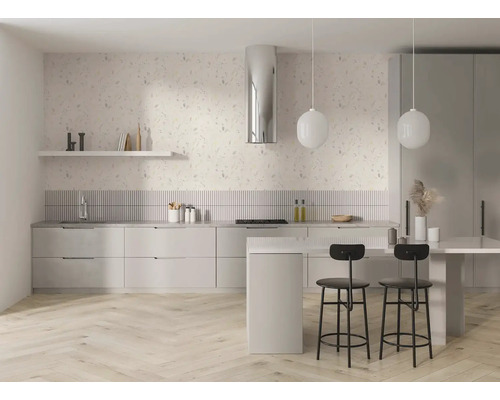 Helle, moderne Küche mit floraler Tapete, gestreiftem Spritzschutz, Kochinsel, schwarzen Barhockern und hellem Boden in Fischgrätoptik.