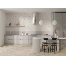 Helle, moderne Küche mit floral gemusterter Vliestapete an der Wand, hellen Fronten, einer Kücheninsel mit Barhockern und Fischgrät-Parkettboden.