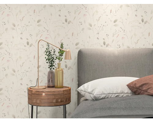 Helle Vliestapete mit feinem floralem Muster aus Gräsern und Blüten in einem modern eingerichteten Schlafzimmer mit grauem Bett und Holznachttisch.