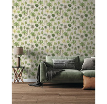 Salon moderne avec papier peint à motif de palmiers, canapé vert avec coussins, table d'appoint avec lampe et sol en bois.