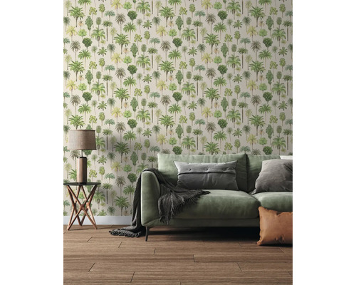 Salon moderne avec papier peint à motif de palmiers, canapé vert avec coussins, table d'appoint avec lampe et sol en bois.