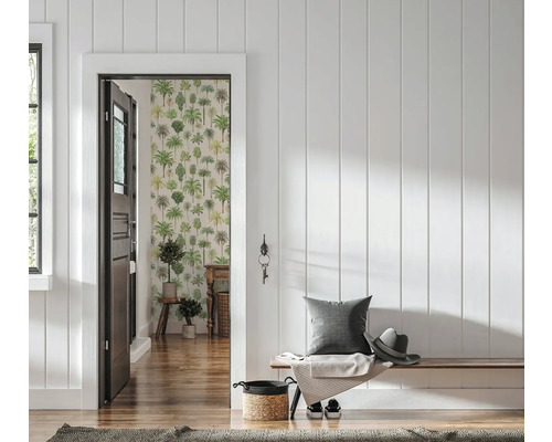 Couloir lumineux avec lambris blanc, banc en bois avec coussin et chapeau, vue sur une pièce avec papier peint motifs palmiers.