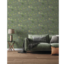Papier peint avec motif de palmiers dans un salon avec canapé vert, table d'appoint et sol en bois.