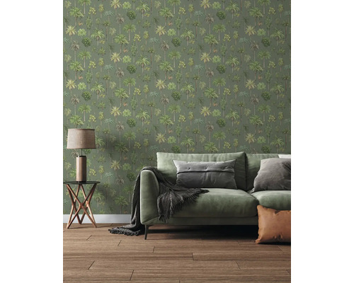 Papier peint avec motif de palmiers dans un salon avec canapé vert, table d'appoint et sol en bois.